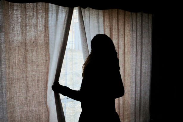 silhouette-of-woman-standing-by-window-looking-out